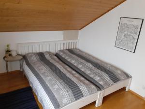 a bed in a room with a wooden ceiling at Gästewohnung in Parkstetten bei Straubing in Parkstetten +11 photos