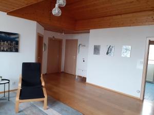 a room with a chair and a white wall at Gästewohnung in Parkstetten bei Straubing in Parkstetten