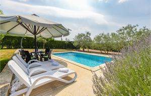 a pair of chairs and an umbrella next to a swimming pool at Holiday Home Livaki Iv in Muntrilj +46 photos