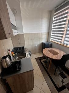 a small kitchen with a sink and a table at Apartman RISTIC in Vranje