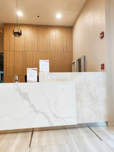 a lobby with a white counter with a sign that reads tower at 319 Tower 4 Avida Atria Iloilo Comfy Cozy Central Studio Unit in Iloilo City