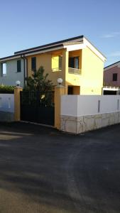 a yellow house with a fence in front of it at SicilyHome in Marzamemi