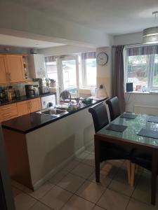 a kitchen with a counter and a table with chairs at Small double room Bromborough Wirral in Bromborough