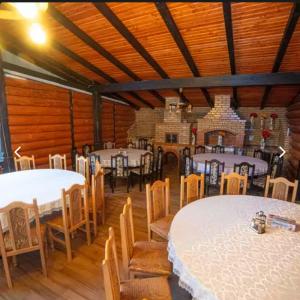 Un comedor con mesas y sillas blancas en una habitación. en Căsuța din livadă, en Capu Cîmpului 4 fotos más