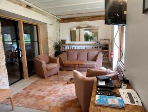 una sala de estar con un sofá y una mesa en La Bergerie de Bénéauville 7 personnes, en Bavent