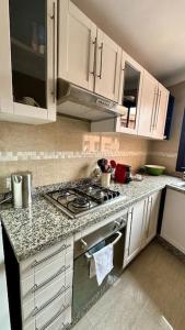 a kitchen with white cabinets and a stove top oven at Flat Moderne in Marrakech +24 photos