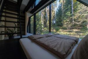 a bed in a room with a large window at Pine chalet in Smižany +76 photos