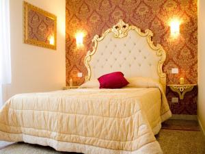a bedroom with a white bed with a red pillow on it at Re di Luna B&B in Rome