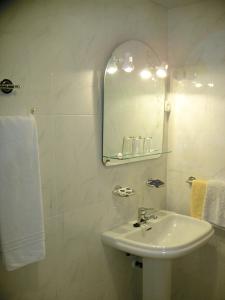 a white bathroom with a sink and a mirror at Hotel La Parra in Archena