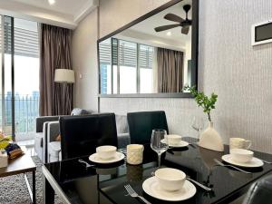 a dining room with a table and chairs and a mirror at Encorp Marina Puteri Harbour Bathtub Netflix in Iskandar Puteri