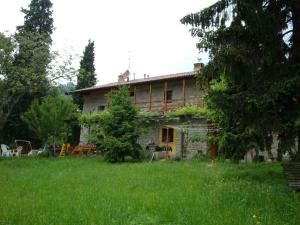 una casa vieja en un campo de césped verde en Agriturismo Cascina Ronchi en Palazzago