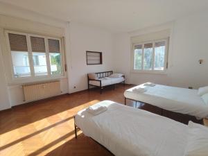 Dock Bay في ترييستي: غرفة بسريرين وكرسي ونوافذ +4 صور