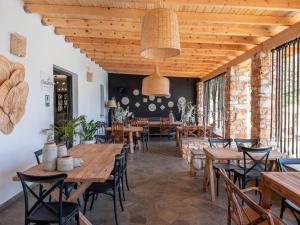 an empty restaurant with wooden tables and chairs at Parosland Hotel in Aliki