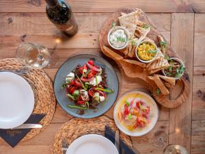 a wooden table with plates of food on it at Parosland Hotel in Aliki