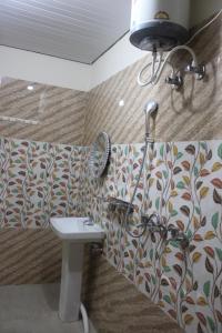 a bathroom with a shower and a sink and a mirror at Kyarki Village Homestay & Cafe in Rishīkesh +157 photos