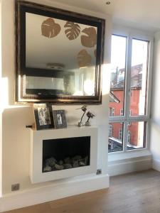 a living room with a television above a fireplace at La petite Venise des Alpes, Ultra centre 1 à 5 Pers in Annecy