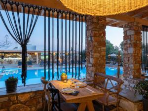 a patio with a table and a swimming pool at Parosland Hotel in Aliki