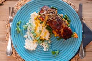 a blue plate with food on a table at Parosland Hotel in Aliki