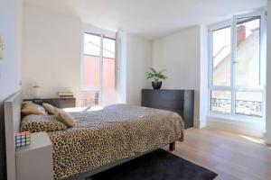 a bedroom with a leopard print bed and windows at La petite Venise des Alpes, Ultra centre 1 à 5 Pers in Annecy