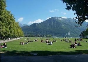 a group of people sitting in the grass in a park at La petite Venise des Alpes, Ultra centre 1 à 5 Pers in Annecy