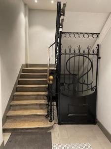 a hallway with a staircase with a black door and a staircasengthngthngthngth at La petite Venise des Alpes, Ultra centre 1 à 5 Pers in Annecy