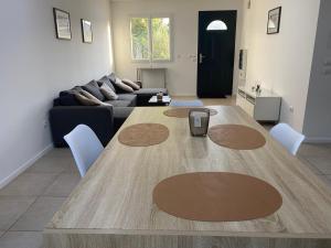 ein Wohnzimmer mit einem Holztisch und einer Couch in der Unterkunft Maison Familiale et chaleureuse ALBI in Lescure-dʼAlbigeois
