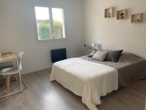 ein Schlafzimmer mit Bett, Schreibtisch und Fenster in der Unterkunft Maison Familiale et chaleureuse ALBI in Lescure-dʼAlbigeois