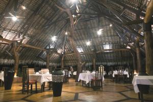 a restaurant with tables and chairs and a large wooden ceiling at Ravintsara Wellness Hotel in Ambaro