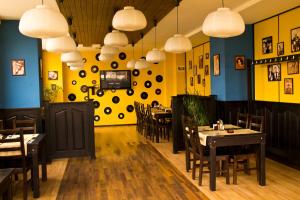 a dining room with tables and chairs and yellow walls at Hotel City Ploiesti in Ploieşti