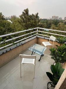 プネにあるSpring Studio Apartment Opp Passport Office with AC Balcony WiFi Kitchenetteのパティオ(椅子2脚、テーブル付)
