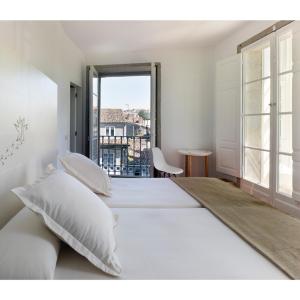 Un dormitorio blanco con una cama grande y una ventana en Hotel Pazo de Altamira en Santiago de Compostela