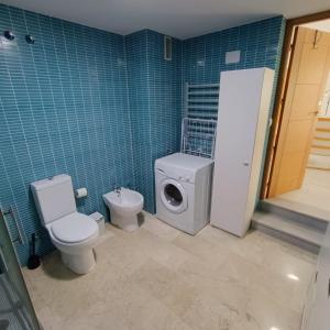 a bathroom with a toilet and a washing machine at El Rincón de Don Gonzalo in Puente Genil