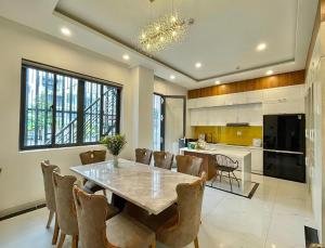 a kitchen and dining room with a table and chairs at Khách sạn Miami Ninh Thuận in Phan Rang–Tháp Chàm