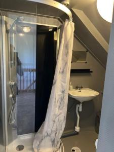 a bathroom with a shower curtain and a sink at Weisbacken in Lönneberga +31 photos