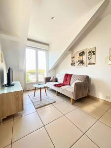 a living room with a couch and a table at Duplex-Trois pas de la Gare in Sartrouville