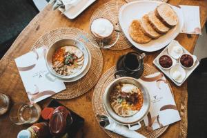 a wooden table with plates of food and bread at Villa De View in Ban Tham