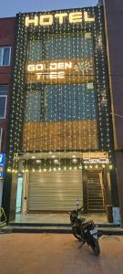 a motorcycle parked in front of a building with lights at Hotel golden tree in Hisār +18 photos