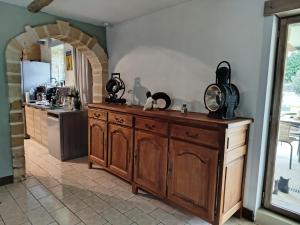 a kitchen with a cat sitting on top of a wooden cabinet at Chambre à la Campagne in Connage