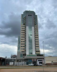 un edificio alto con macchine parcheggiate di fronte di Apartamento 1 quarto - Taguatinga Centro - Lazer Completo, Garagem, ao lado do metrô a Brasilia