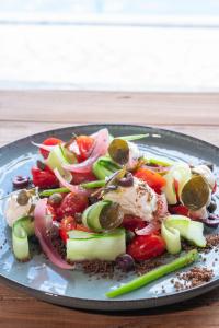 a plate of food with vegetables on a table at Parosland Hotel in Aliki