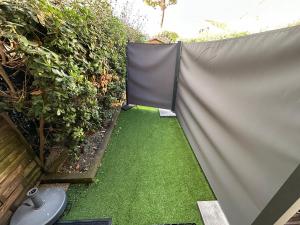 ein Garten mit Sichtschutzzaun und Gras in der Unterkunft U MUCHJU, studio Marana - à la nuitée in Borgo + 6 Fotos