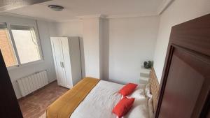 a bedroom with a bed with red pillows on it at Casa Frijol 20metres from the beach in Los Alcázares