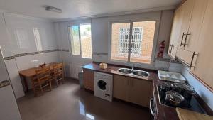 a kitchen with a sink and a washing machine at Casa Frijol 20metres from the beach in Los Alcázares
