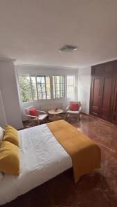 a bedroom with a large bed with a yellow blanket at Casa Frijol 20metres from the beach in Los Alcázares