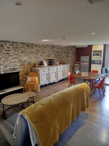 a living room with a couch and tables and a kitchen at Chez Pauline & Vincent Côté Canal in Carcassonne