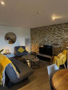 a living room with a couch and a tv at Chez Pauline & Vincent Côté Canal in Carcassonne