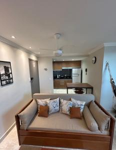 un soggiorno con un divano con cuscini di Apartamento 1 quarto - Taguatinga Centro - Lazer Completo, Garagem, ao lado do metrô a Brasilia