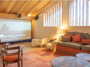 - un salon avec un canapé et un grand écran dans l'établissement Chalet prestige Saint Gervais les Bains, à Saint-Gervais-les-Bains