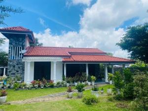 a house with a red roof at Suriya Homestay in Badalgama