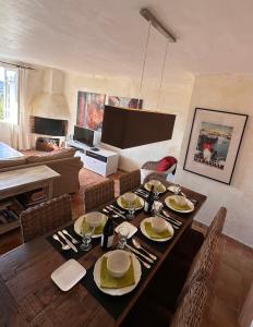 a dining room with a table with chairs and a television at Les 3 Terrasses in Roussillon